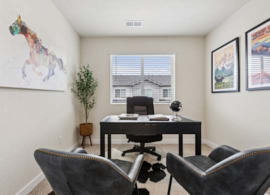 A room with a desk, chairs, and pictures on the wall.