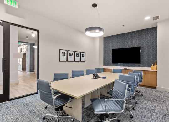 a conference room with a long table and chairs and a tv