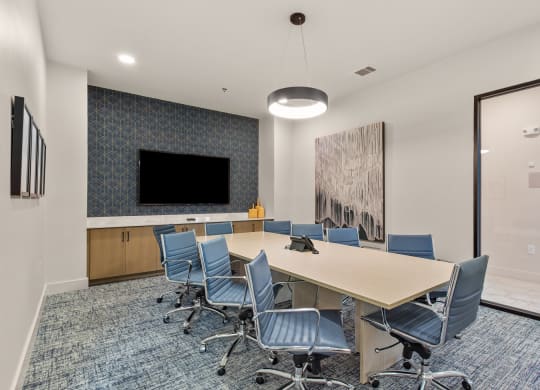 a conference room with a table and chairs and a tv