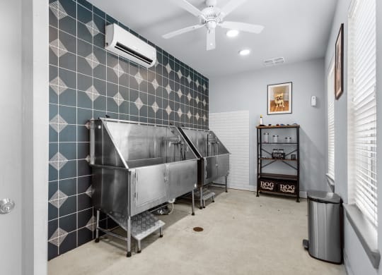 a room with a large stainless steel tub and a ceiling fan
