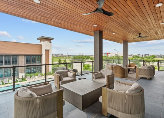 the lobby of a hotel with couches and chairs and a balcony