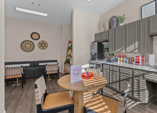 A kitchen area with a table and chairs and a counter with food on it.