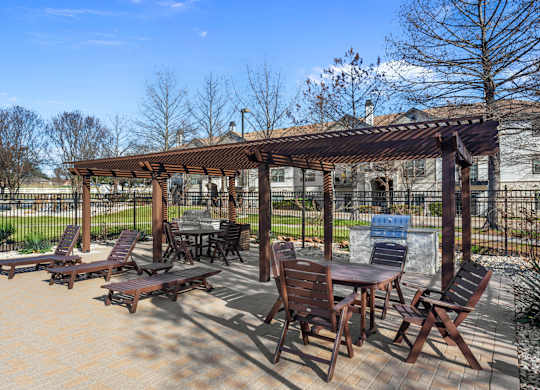 A patio with a table and chairs under a pergola.