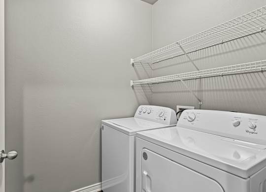 A white washing machine and dryer in a laundry room.