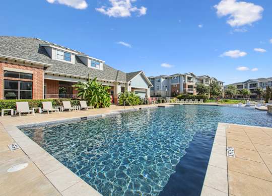 A swimming pool in a residential area with houses in the background.