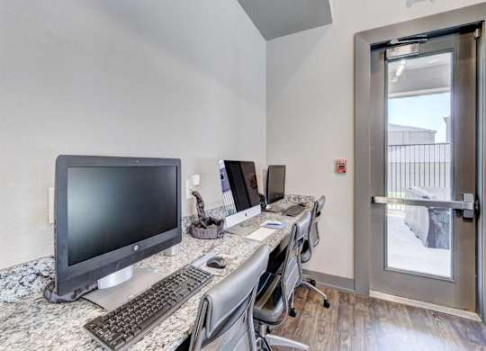 A room with a desk, computer, and chair.