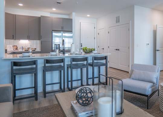 A modern kitchen with a bar area and a living room area.