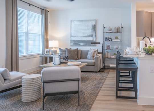 A modern living room with a grey sofa, a white armchair, and a coffee table.