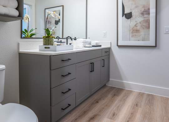 A bathroom with a toilet, sink, and mirror.