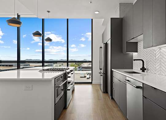 A modern kitchen with a view of the cityscape outside the window.