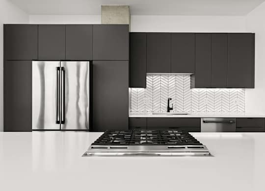 A modern kitchen with a black fridge and a black and white tiled backsplash.