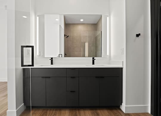 A bathroom with a large mirror and a sink.