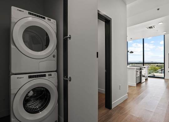 A modern laundry room with a washer and dryer stacked on top of each other.