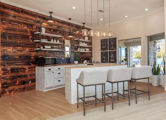 A kitchen with a wooden wall and white countertops.
