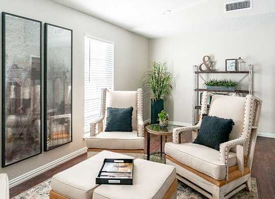 A living room with a white couch, a chair, and a coffee table.