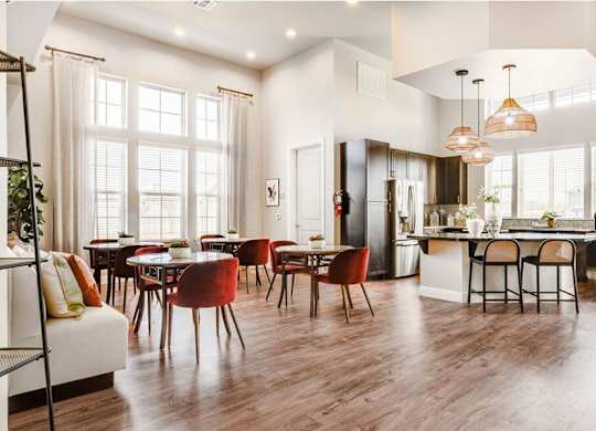 A modern kitchen and dining room with wooden floors and furniture.