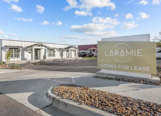 the laramie homes for lease sign in front of the building