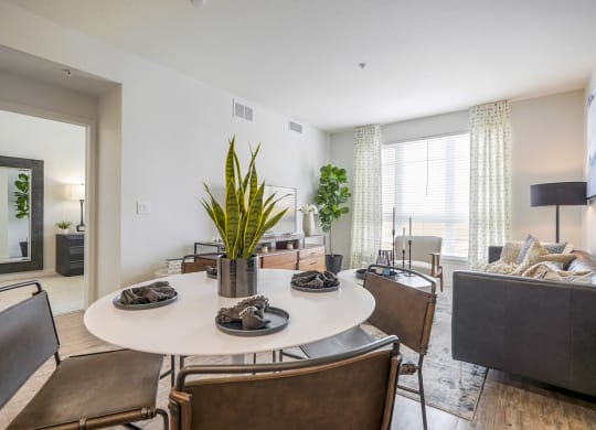 a living room and dining room with a table and chairs