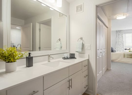 a white bathroom with a large mirror and a sink