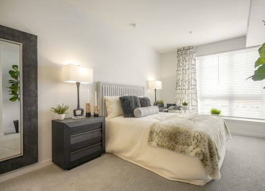 a bedroom with a bed and a large window