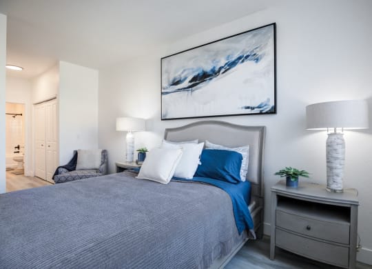 a bedroom with a large bed and a painting on the wall