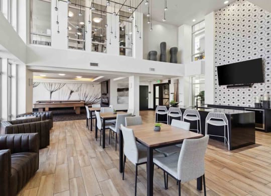a large lobby with tables and chairs and a television
