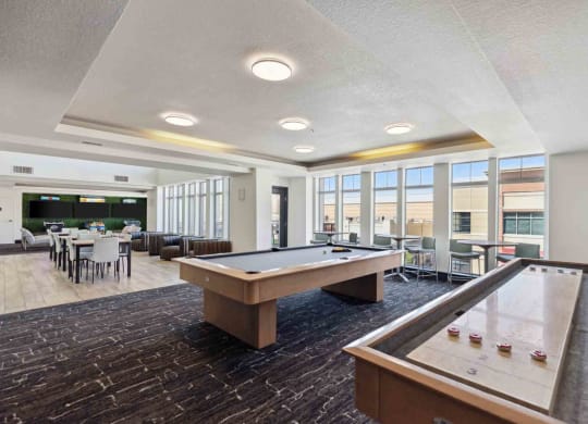 a community room with a pool table and a dining area