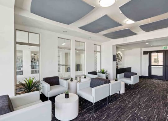 a lobby of a building with white couches and chairs