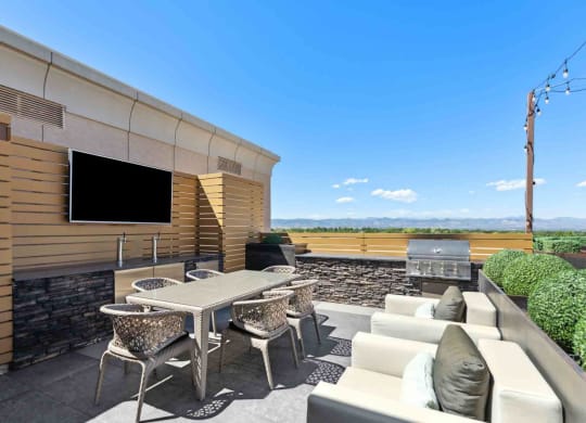 a patio with furniture and a grill on the side of a building