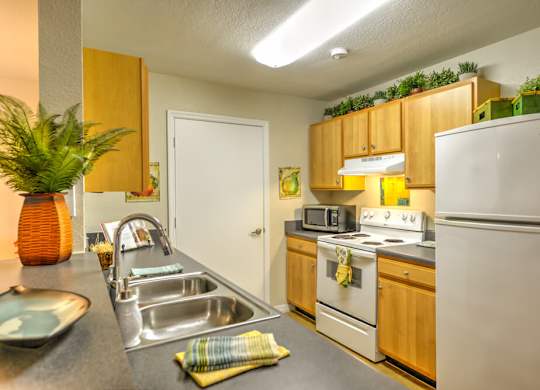 A kitchen with a white refrigerator, stove, and oven.
