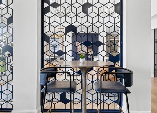 resident lounge area with table and chairs and a geometric pattern on the wall