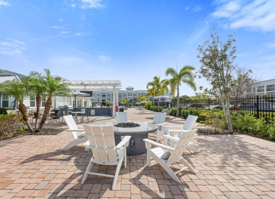 a communalm outdoor area with white chairs and a fire pit