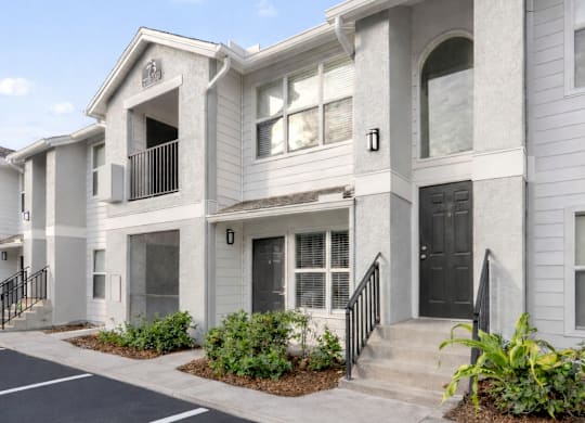 A row of townhouses with a parking lot in front.