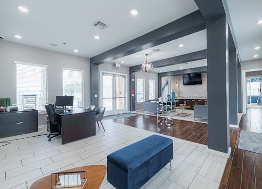 A modern living room with a blue ottoman and a television.