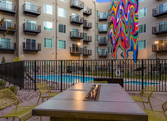 A colorful mural on a building behind a pool.
