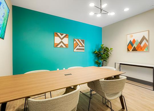A conference room with a long table and chairs.