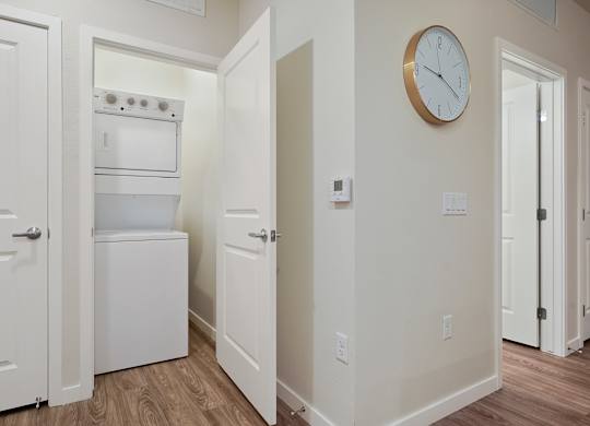 A kitchen with a white oven and a clock on the wall.
