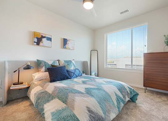 A bedroom with a bed, nightstand, and a lamp.
