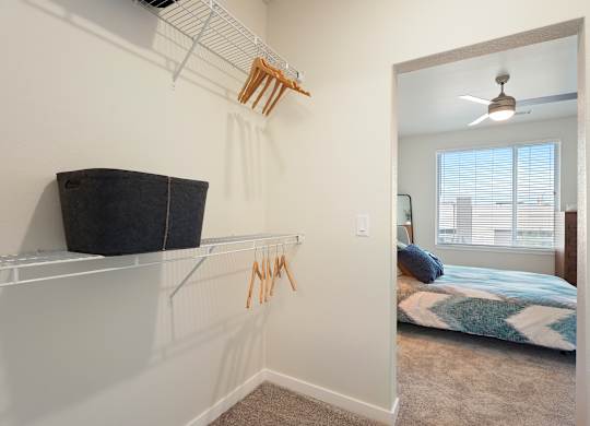 A bedroom with a bed, a window, and a fan.