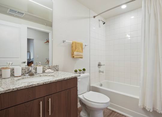 A white bathroom with a toilet, sink, and bathtub.