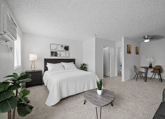 A bedroom with a large bed and a small table.