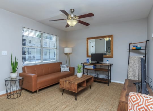 a living room with a ceiling fan and a large window