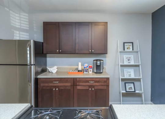 a kitchen with dark wood cabinets and a stainless steel refrigerator