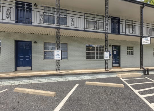 a building with blue doors and windows and a parking lot in front of it