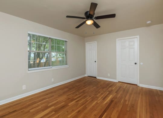 an empty room with a ceiling fan and a window