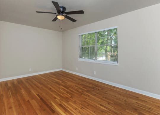 an empty room with a ceiling fan and a window