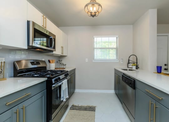 a kitchen with gray cabinets and white countertops