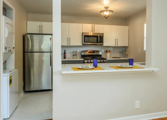 a kitchen with white cabinets and stainless steel appliances