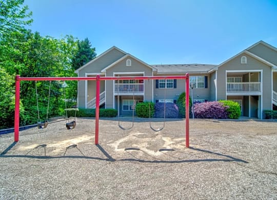 a swing set in front of an apartment building