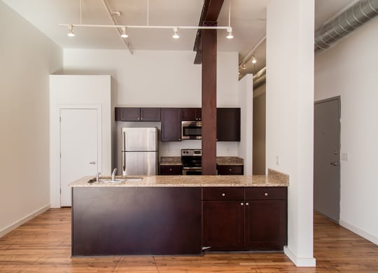 a kitchen with a large island with granite countertops